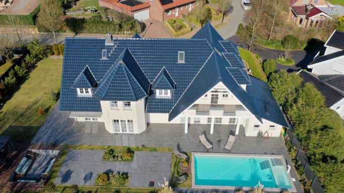 Elegante Villa mit blauen Dach, Schwimmbad und gepflegtem Garten.