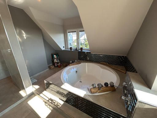 Helles Badezimmer mit einem modernen, freistehenden Whirlpool und Fensterblick.